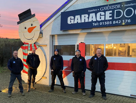 power doors team standing in front of garage door showroom