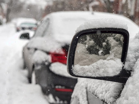 heavily snowed road and snow covered cars